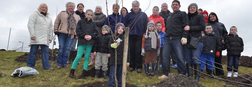 Community Group planting a tree in an orchard